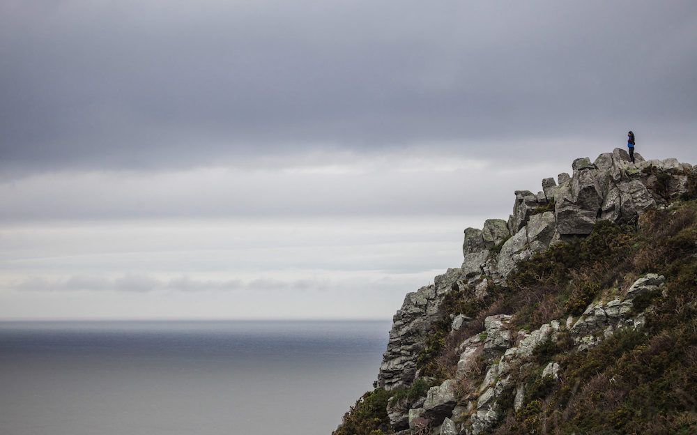 Tobias standing on a rocky outcrop staring out to sea in Exmoor National park